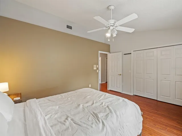 a bedroom with a bed and a ceiling fan