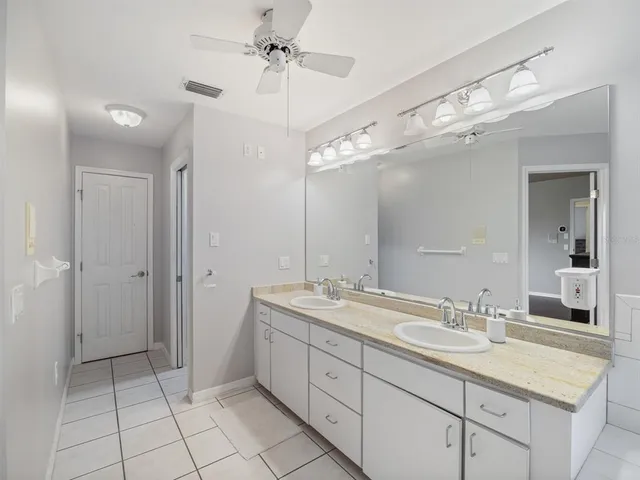 a spacious bathroom with a granite countertop sink a mirror and a shower