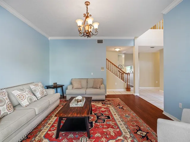 a living room with furniture and a chandelier