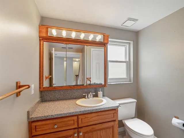 a bathroom with a toilet sink and mirror