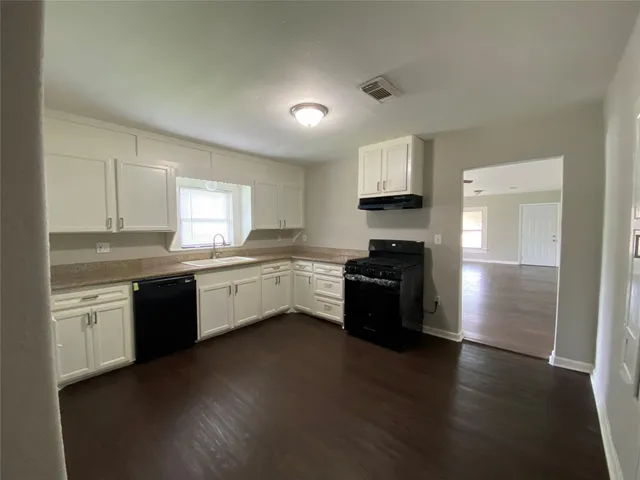 a large kitchen with a stove a sink and a refrigerator
