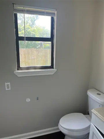 a white toilet sitting next to a window