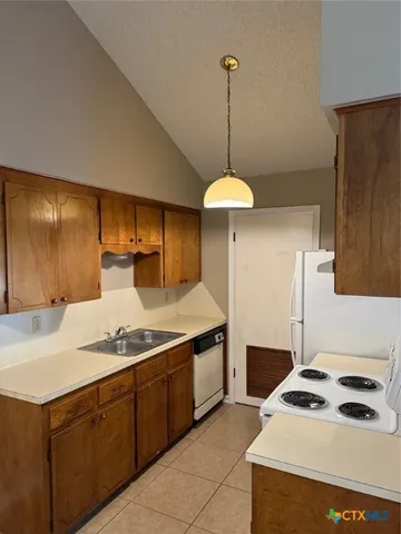 a kitchen with a sink a stove and a refrigerator