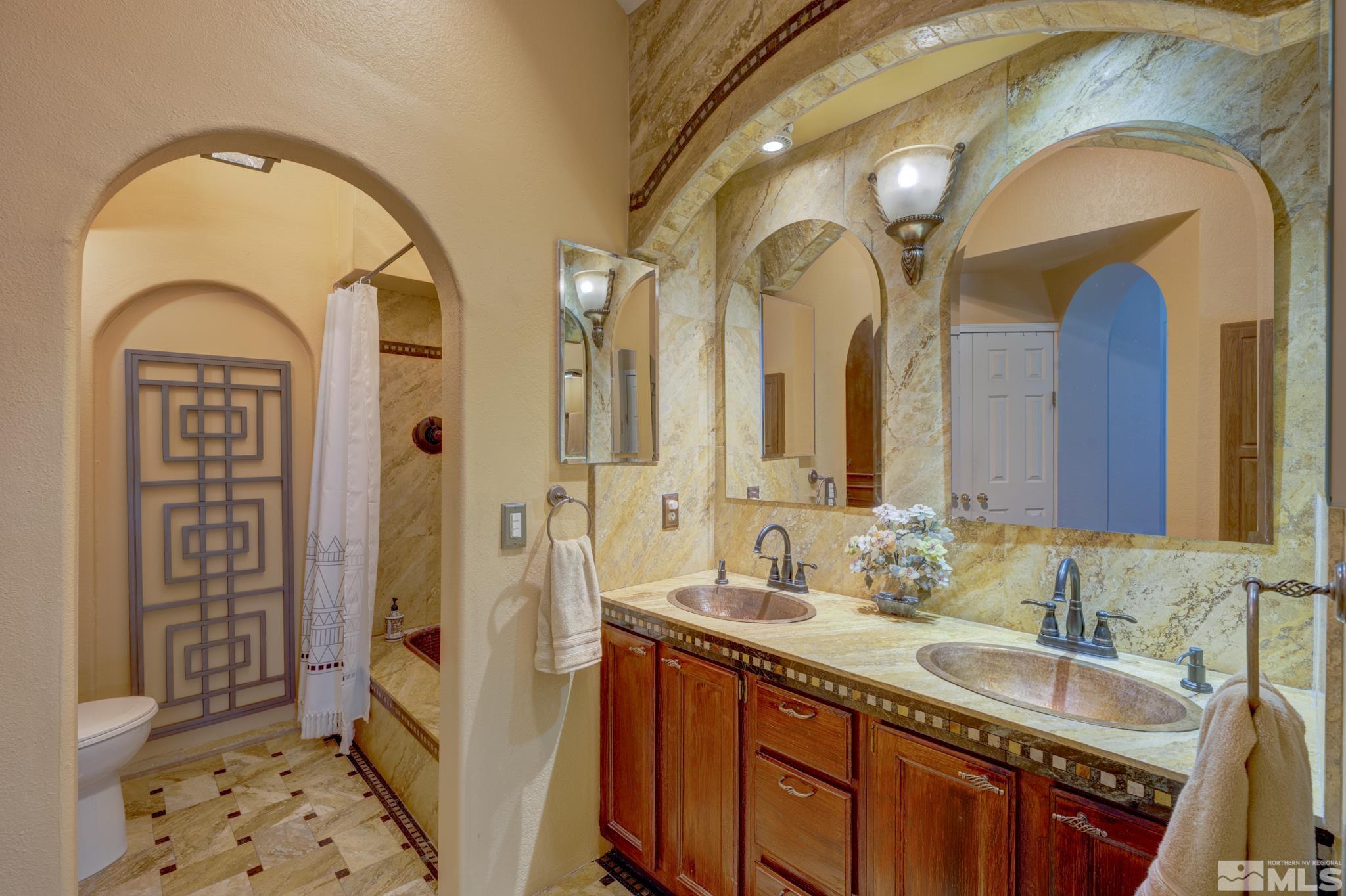 14095 Riata Circle Reno, NV 89521 - Photo 11 of 26 a bathroom with a granite countertop double vanity sink and a mirror