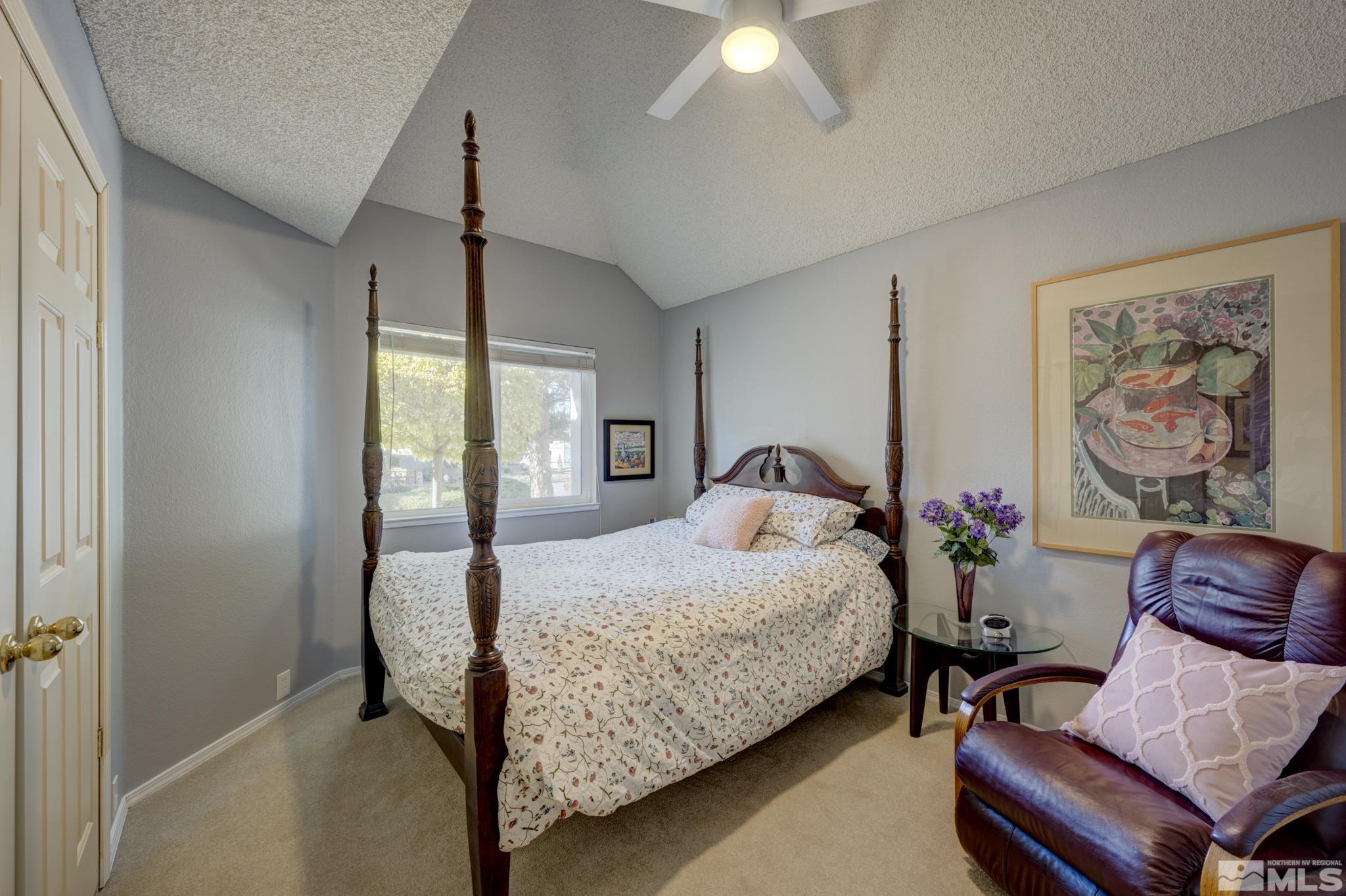 14095 Riata Circle Reno, NV 89521 - Photo 14 of 26 a bedroom with a bed and a chandelier