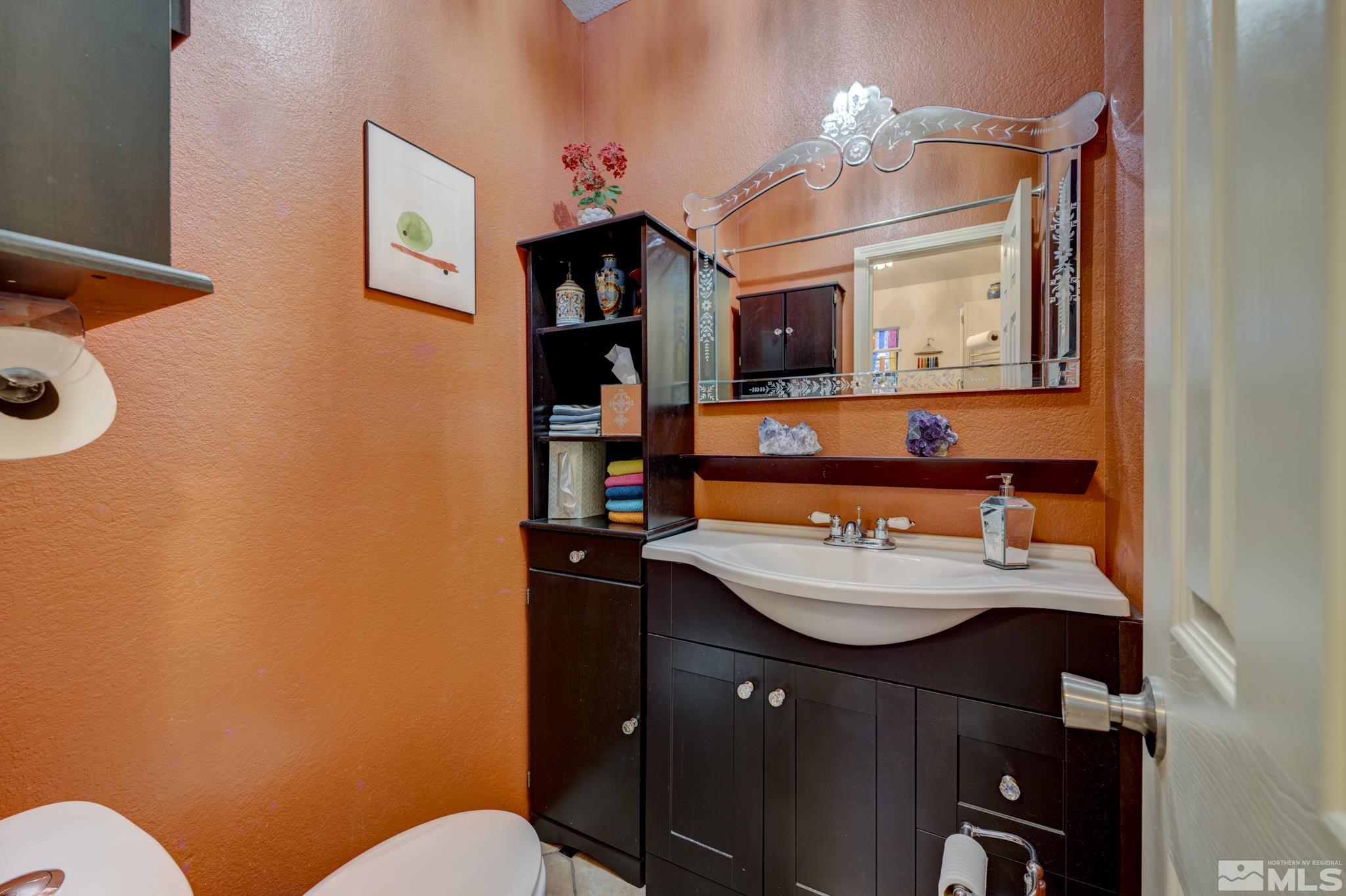 14095 Riata Circle Reno, NV 89521 - Photo 15 of 26 a bathroom with a sink vanity mirror and toilet