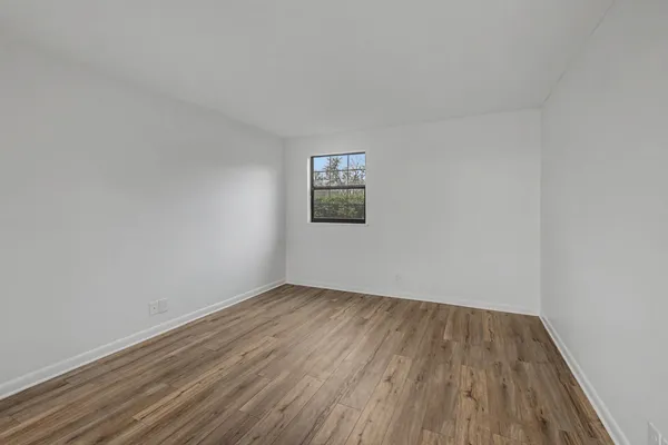 a view of a room with wooden floor and white walls