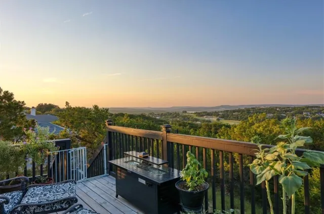 a view of a balcony with wooden floor and iron fence