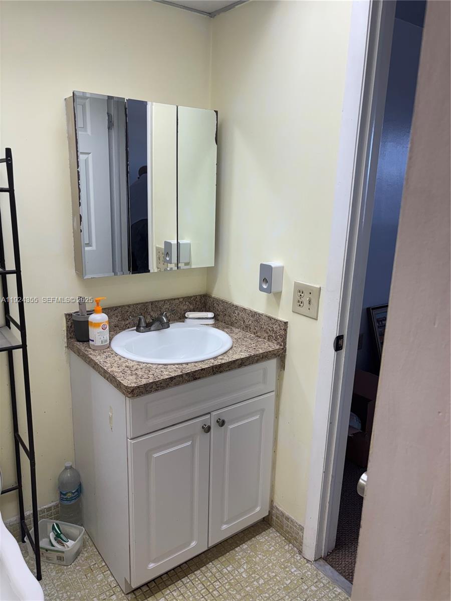 14250 Southwest 62nd Street, Unit 520 Miami, FL 33183 - Photo 11 of 39 a bathroom with a granite countertop sink and a mirror