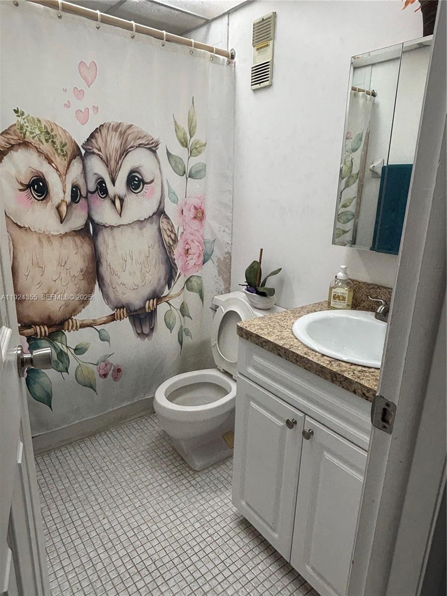 14250 Southwest 62nd Street, Unit 520 Miami, FL 33183 - Photo 14 of 39 a bathroom with a toilet sink and mirror