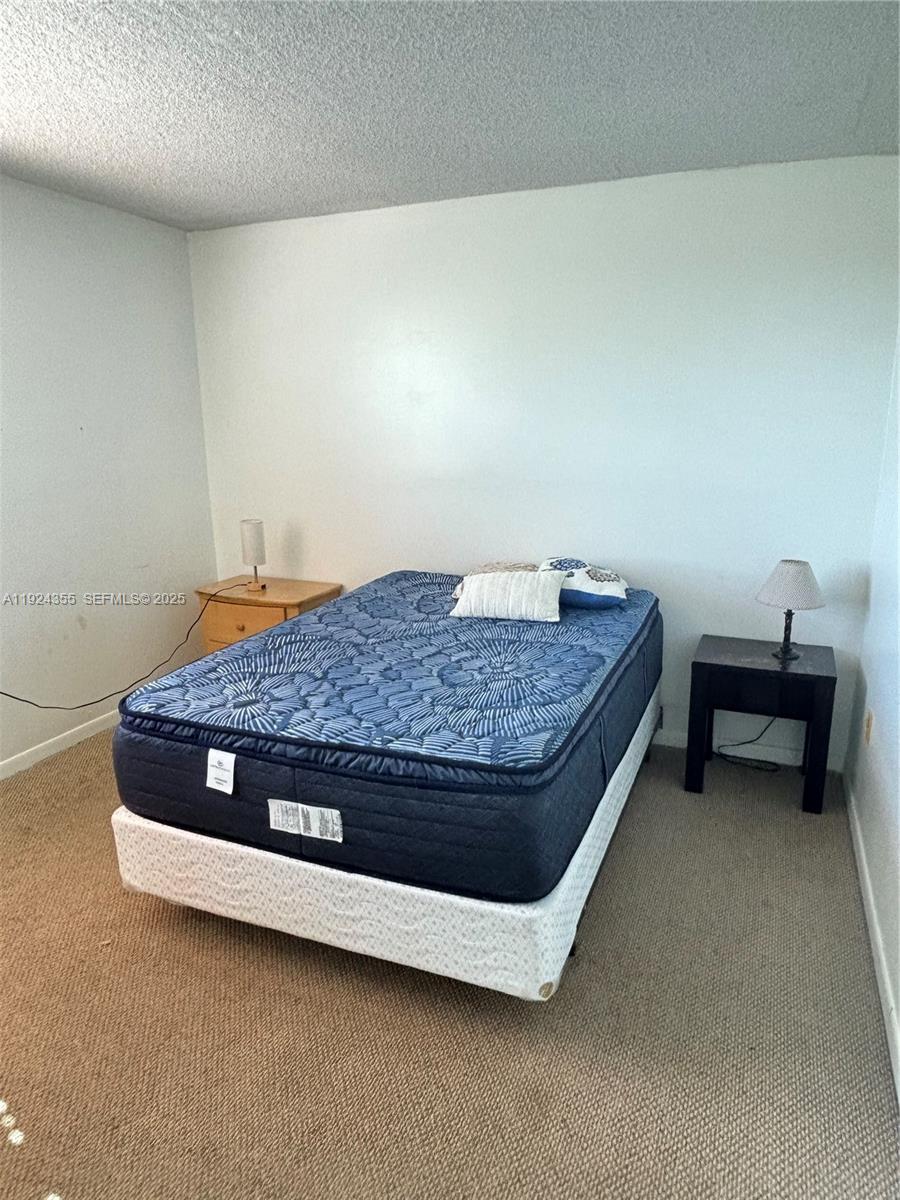 14250 Southwest 62nd Street, Unit 520 Miami, FL 33183 - Photo 15 of 39 a bedroom with a bed and a table in it