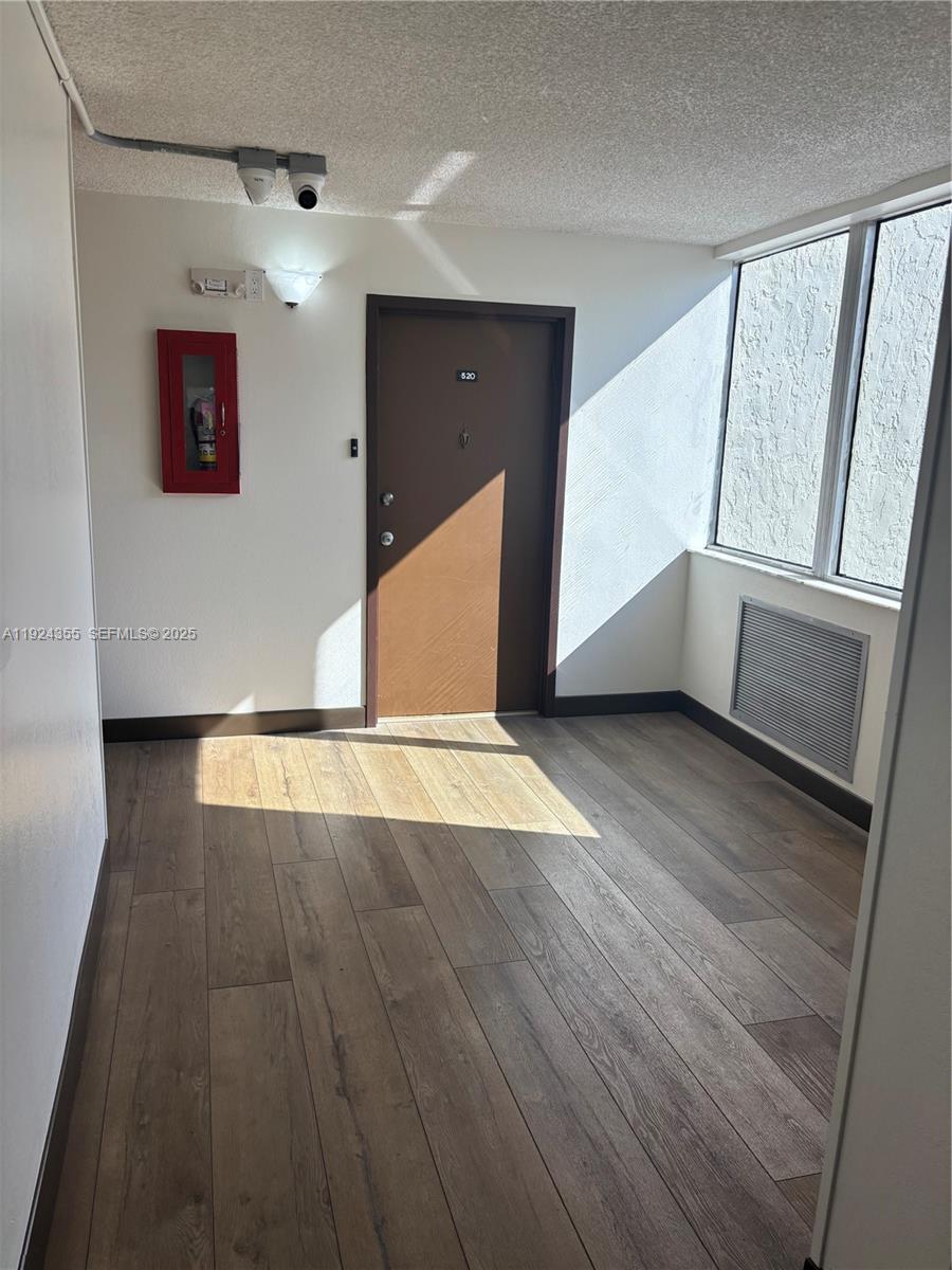 14250 Southwest 62nd Street, Unit 520 Miami, FL 33183 - Photo 19 of 39 a view of an empty room with wooden floor and a window