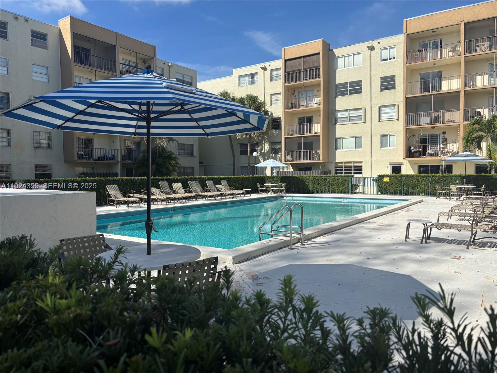 14250 Southwest 62nd Street, Unit 520 Miami, FL 33183 - Photo 23 of 39 a view of a patio with a table and chairs under an umbrella