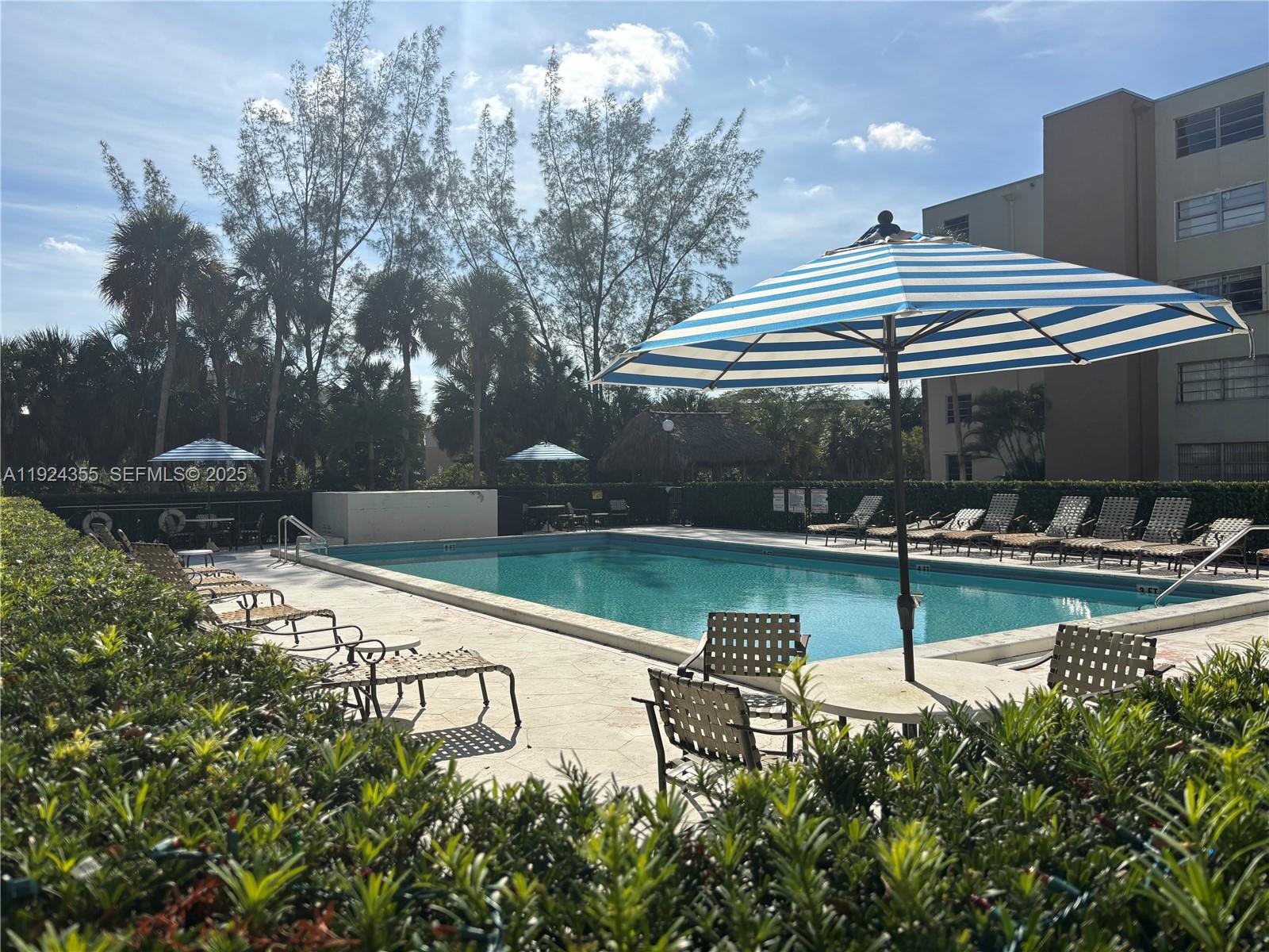 14250 Southwest 62nd Street, Unit 520 Miami, FL 33183 - Photo 25 of 39 a view of swimming pool with a bench and trees in the background