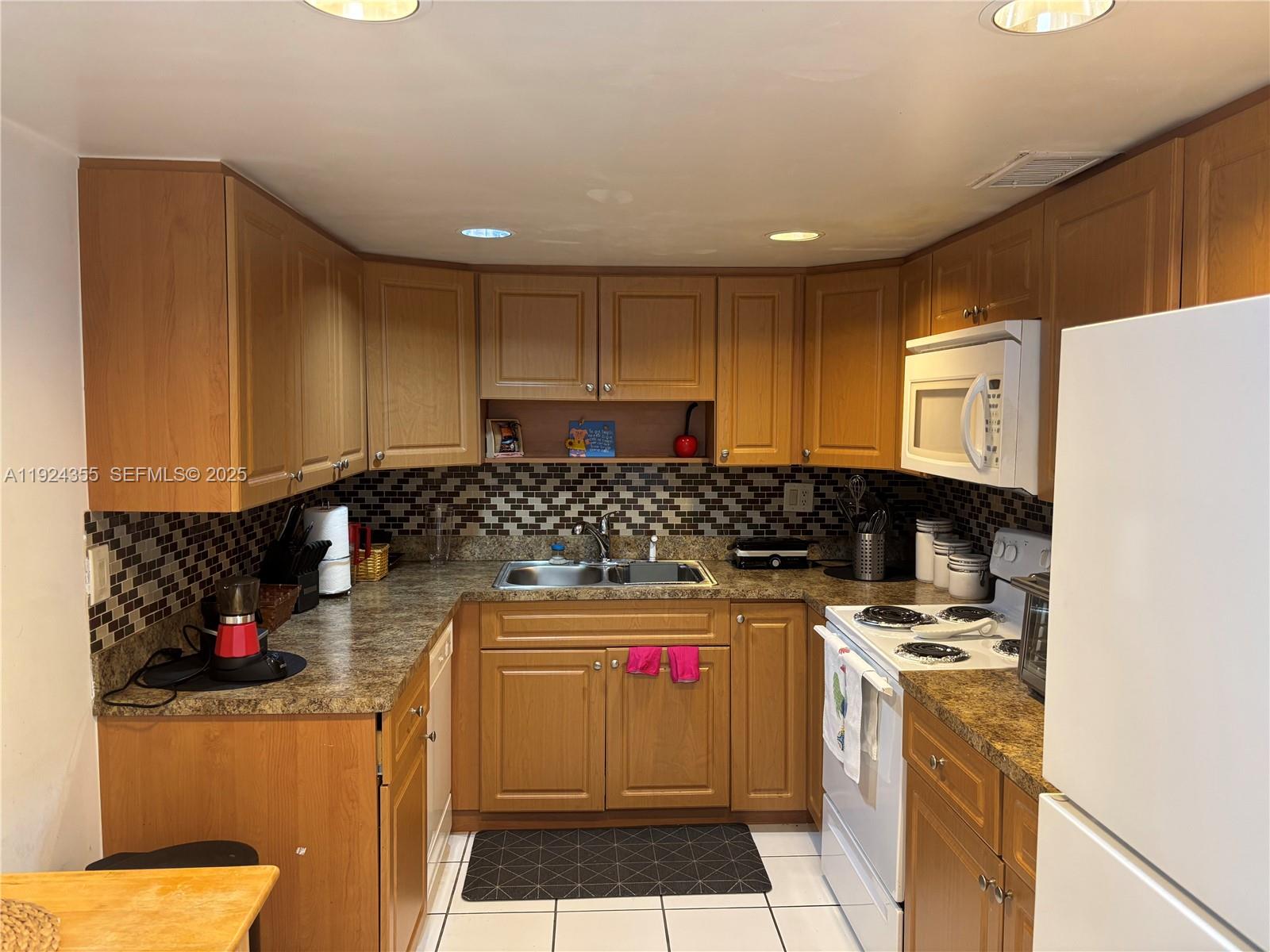 14250 Southwest 62nd Street, Unit 520 Miami, FL 33183 - Photo 5 of 39 a kitchen with stainless steel appliances granite countertop a stove a sink and a refrigerator