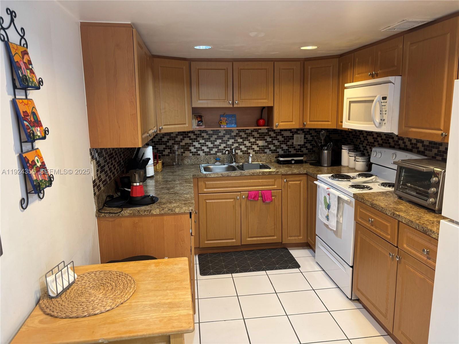 14250 Southwest 62nd Street, Unit 520 Miami, FL 33183 - Photo 6 of 39 a kitchen with a sink a stove and cabinets