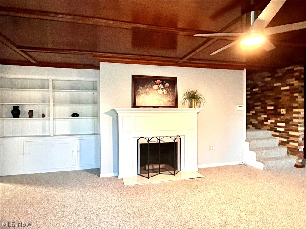 2752 Copley Road Akron, OH 44321 - Photo 9 of 35 Unfurnished living room with carpet, a fireplace with flush hearth, and a ceiling fan