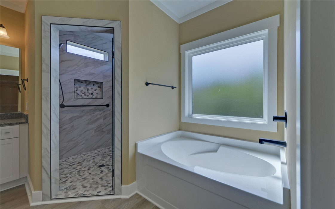 111 Topher Street Hartwell, GA 30643 - Photo 20 of 38 This primary bathroom features a spacious soaking tub and a sleek, modern shower.