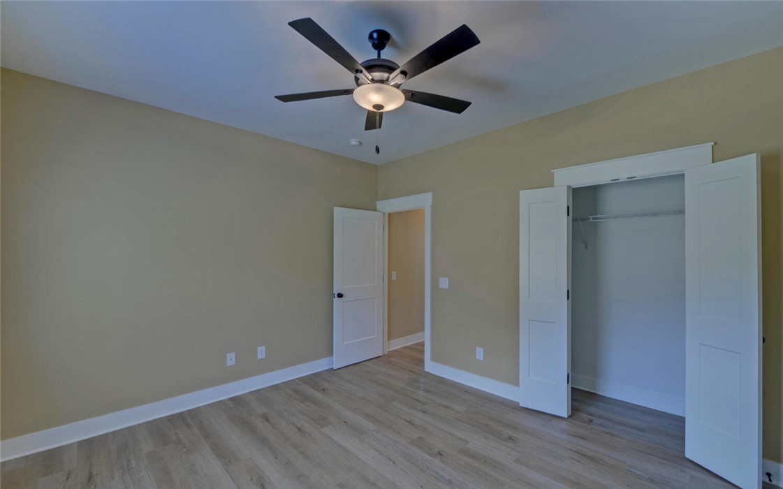 111 Topher Street Hartwell, GA 30643 - Photo 28 of 38 This spacious bedroom offers comfortable living with a modern ceiling fan and ample closet space.