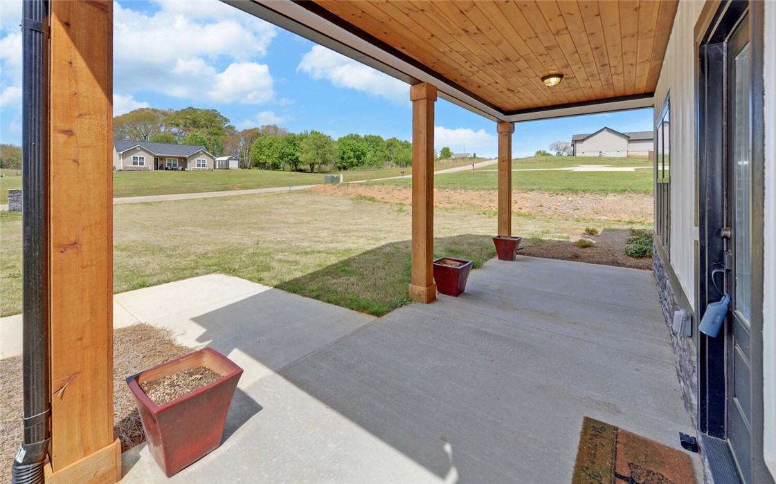 111 Topher Street Hartwell, GA 30643 - Photo 4 of 38 This inviting porch welcomes you home with ample space for outdoor enjoyment and serene landscape views.
