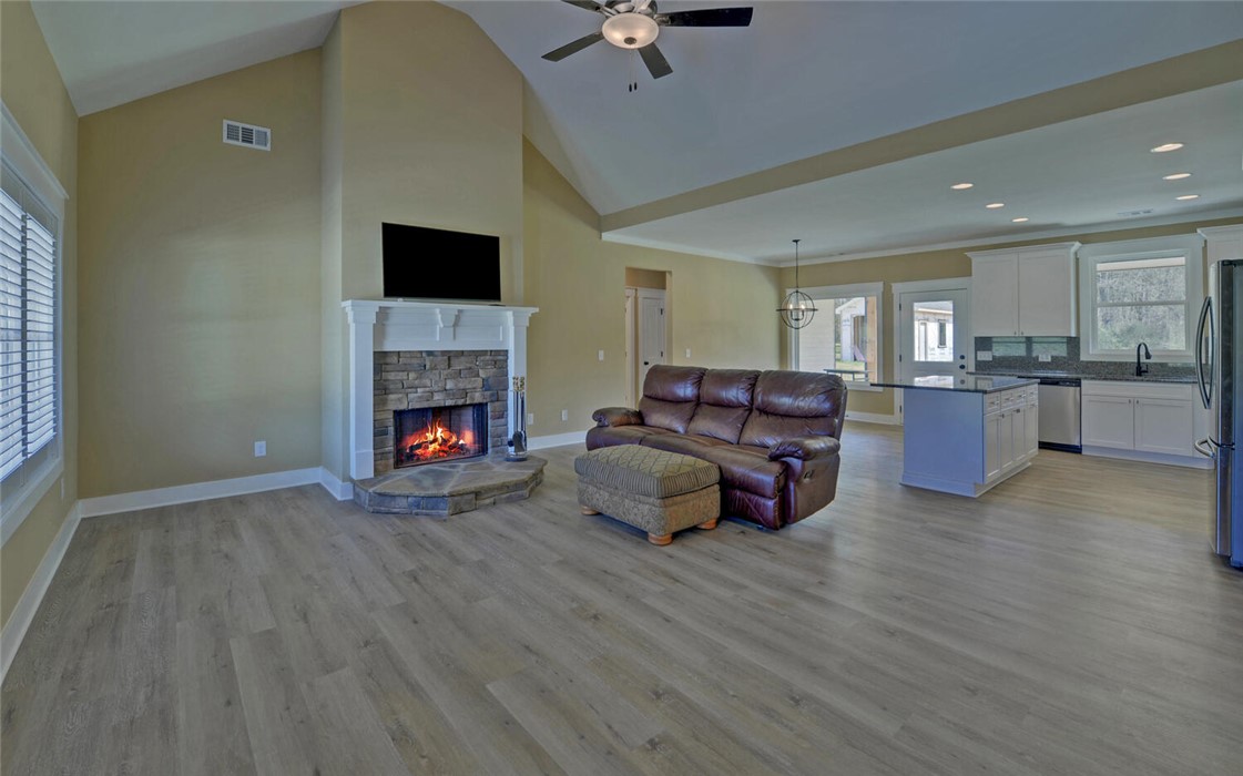 111 Topher Street Hartwell, GA 30643 - Photo 5 of 38 Warm and inviting, this open-concept living space features a cozy fireplace, seamlessly connecting to the kitchen.