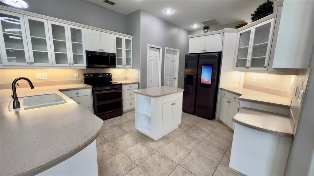 2049 Larissa Court Trinity, FL 34655 - Photo 5 of 61 a kitchen with stainless steel appliances kitchen island granite countertop a refrigerator and a stove top oven