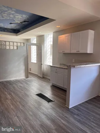 a view of a kitchen with wooden floor and electronic appliances