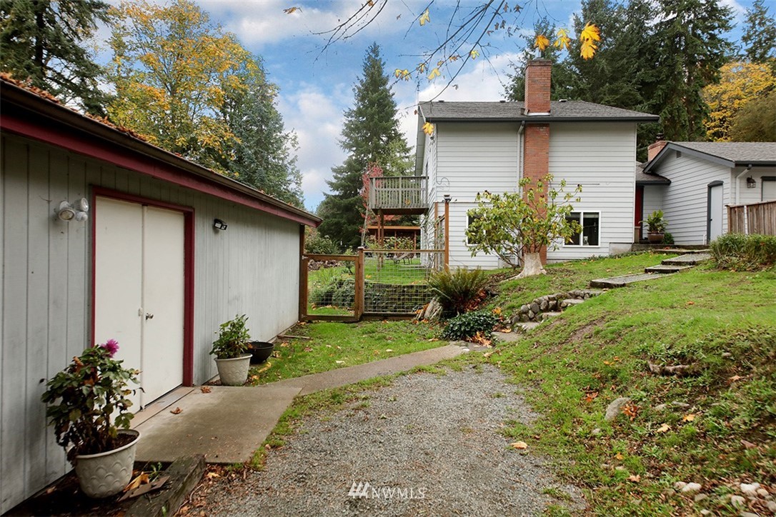 6793 Sills Road Clinton, WA 98236 - Photo 23 of 37 a backyard of a house with table and chairs potted plants