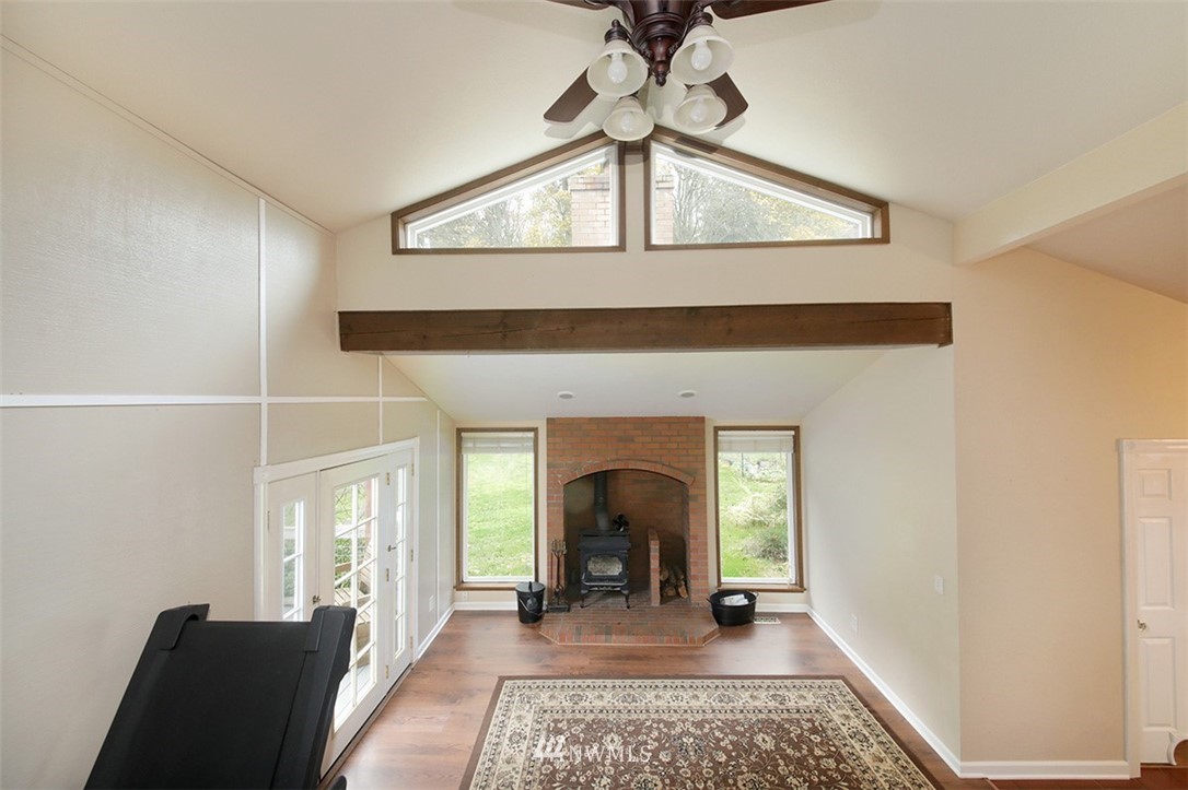 6793 Sills Road Clinton, WA 98236 - Photo 5 of 37 a view of a livingroom with wooden floor and a ceiling fan