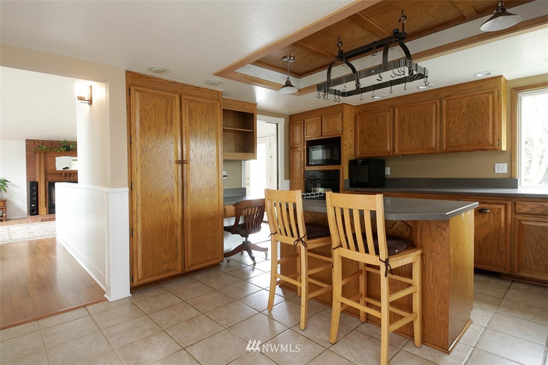 6793 Sills Road Clinton, WA 98236 - Photo 10 of 37 a kitchen with stainless steel appliances kitchen island granite countertop a refrigerator and microwave