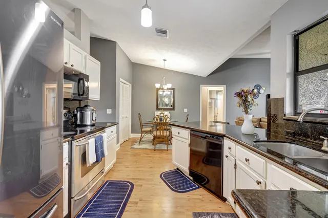 a large kitchen with a lot of counter space and wooden floor