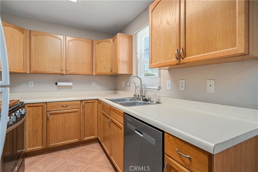 309 North Fairview Street Ridgecrest, CA 93555 - Photo 11 of 30 a kitchen with stainless steel appliances granite countertop a sink a stove and white cabinets