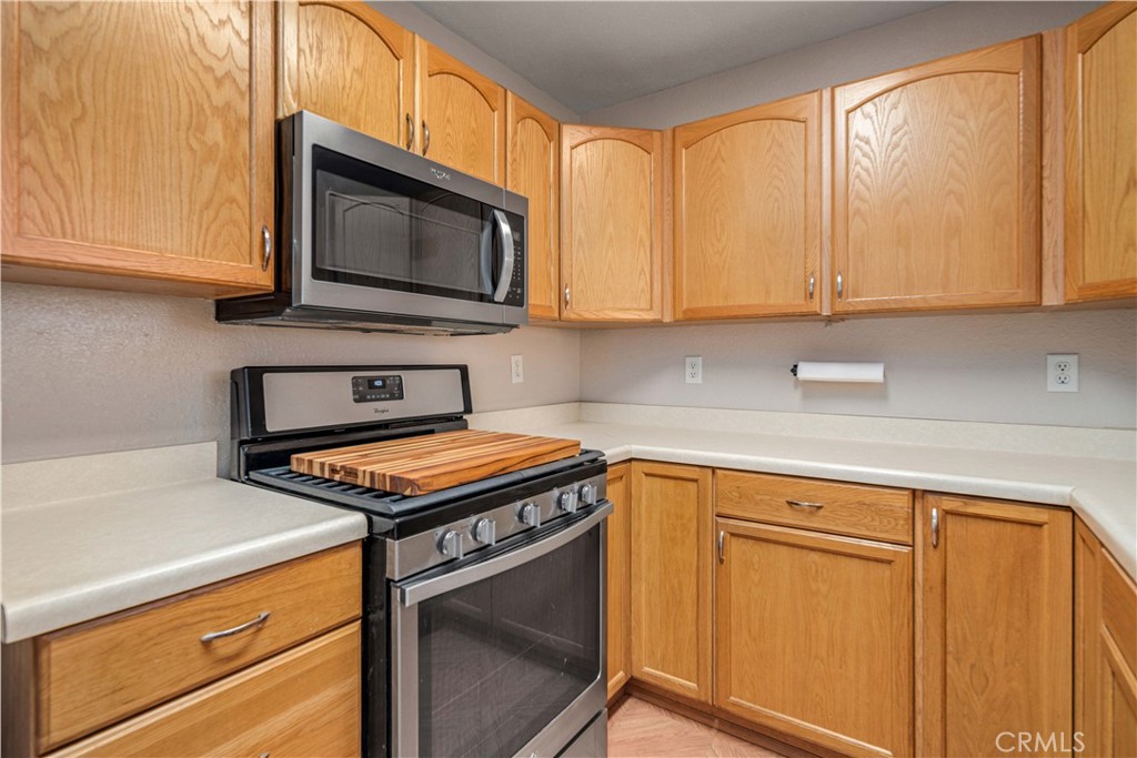 309 North Fairview Street Ridgecrest, CA 93555 - Photo 12 of 30 a kitchen with stainless steel appliances granite countertop white cabinets and a stove top oven