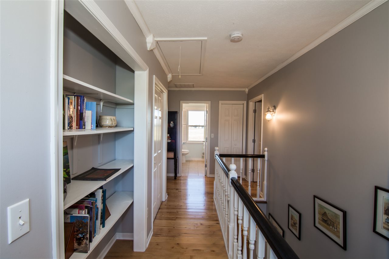9139 Centerville Road Bridgewater, VA 22812 - Photo 30 of 50 a hallway with wooden floor book shelf and stairs