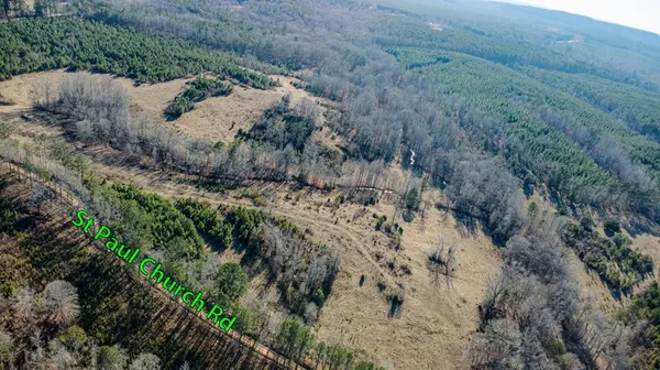 a view of a dry field with trees