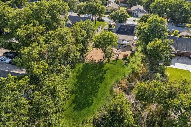 an aerial view of residential house with outdoor space and trees all around