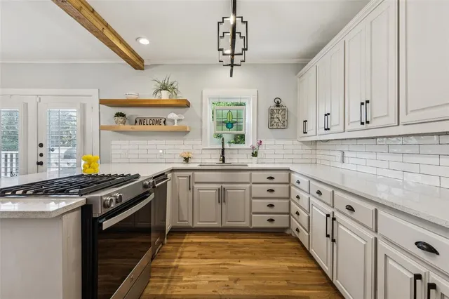 a kitchen with stainless steel appliances granite countertop a sink stove and cabinets