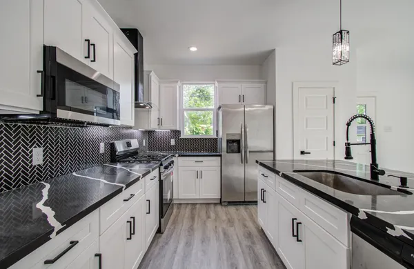 a kitchen with a sink stove and microwave