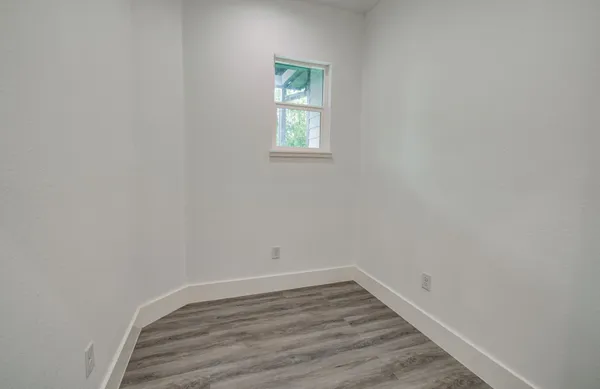 a view of a room that has wooden floor and window