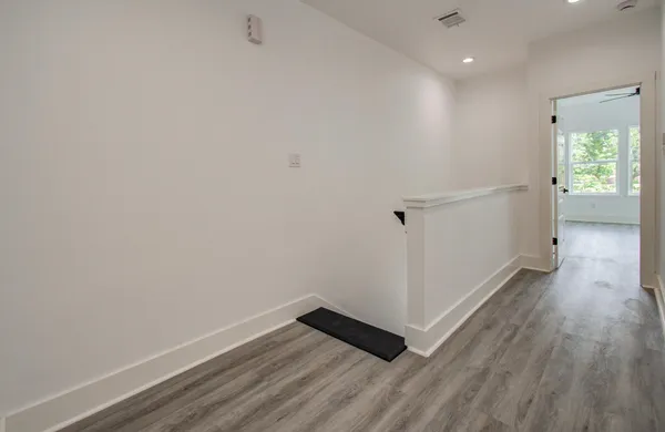 a view of a hallway with wooden floor