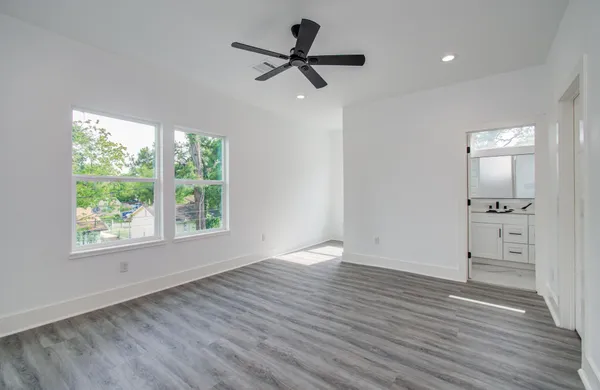 a view of empty room with wooden floor and window
