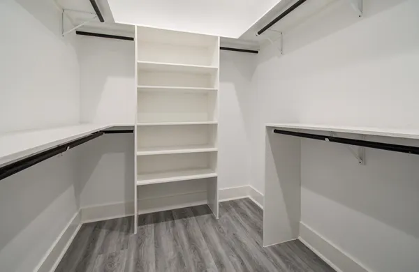 a view of walk in closet with empty racks