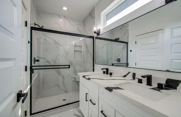 a bathroom with a sink vanity mirror and shower