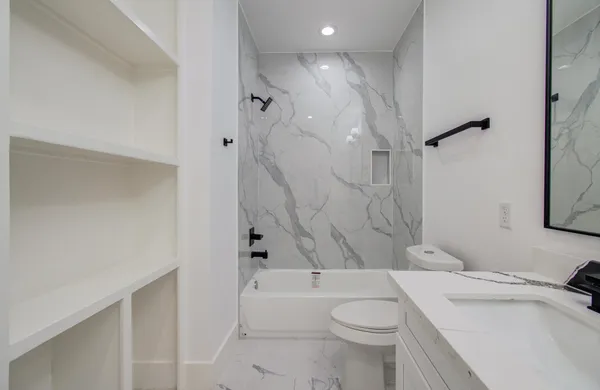 a bathroom with a sink toilet vanity and shower