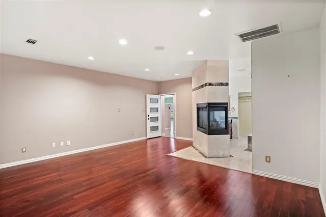 an empty room with wooden floor and fireplace