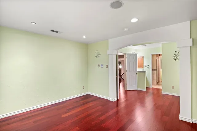 a view of empty room with wooden floor