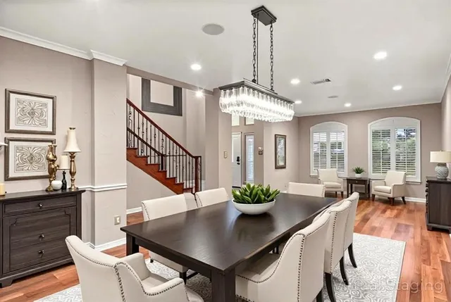 a dining room with furniture a chandelier and wooden floor