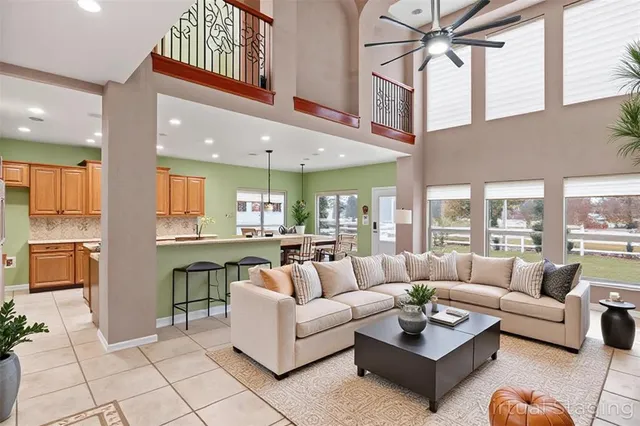a living room with furniture kitchen view and a large window
