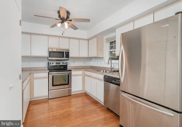 a kitchen with cabinets stainless steel appliances and a counter space