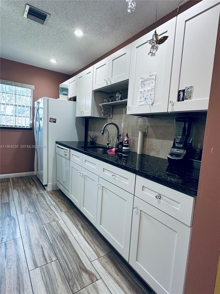 5260 Nesting Way, Unit B Delray Beach, FL 33484 - Photo 7 of 9 a kitchen with stainless steel appliances granite countertop a sink and cabinets